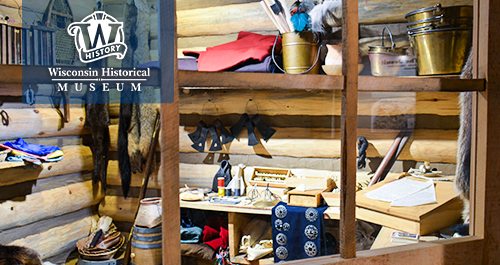 Wisconsin Historical Museum. A museum exhibit showcasing a variety of historic objects in a rustic looking wood cabinet.